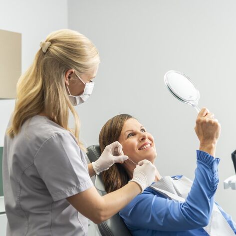 Patientin blickt in den Spiegel