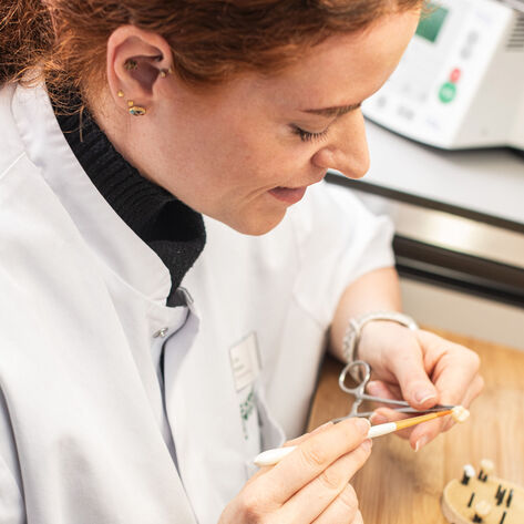 Zahntechnikerin bearbeitet Zahnersatz